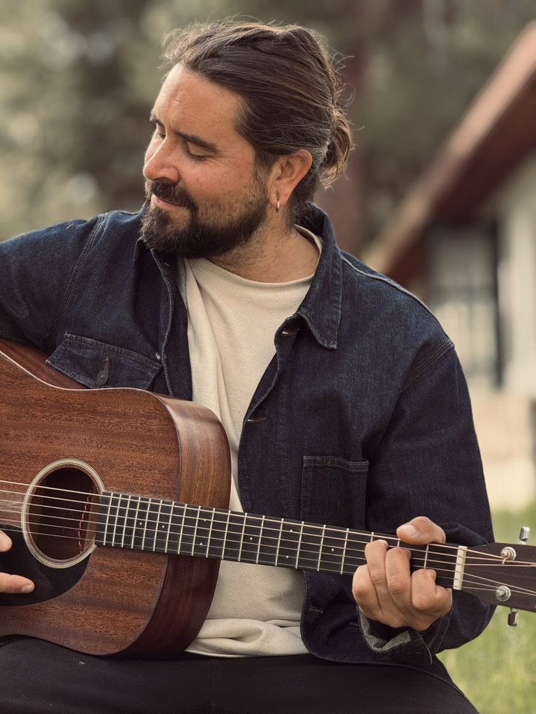Julien Zèle jouant de la guitare acoustique en extérieur
